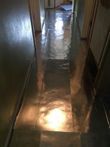 We laid underlayment in the hallway after getting the floor level and sanded