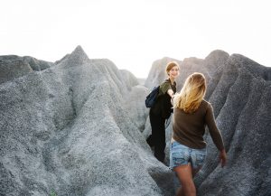getting a helping hand from a friend to climb rocks