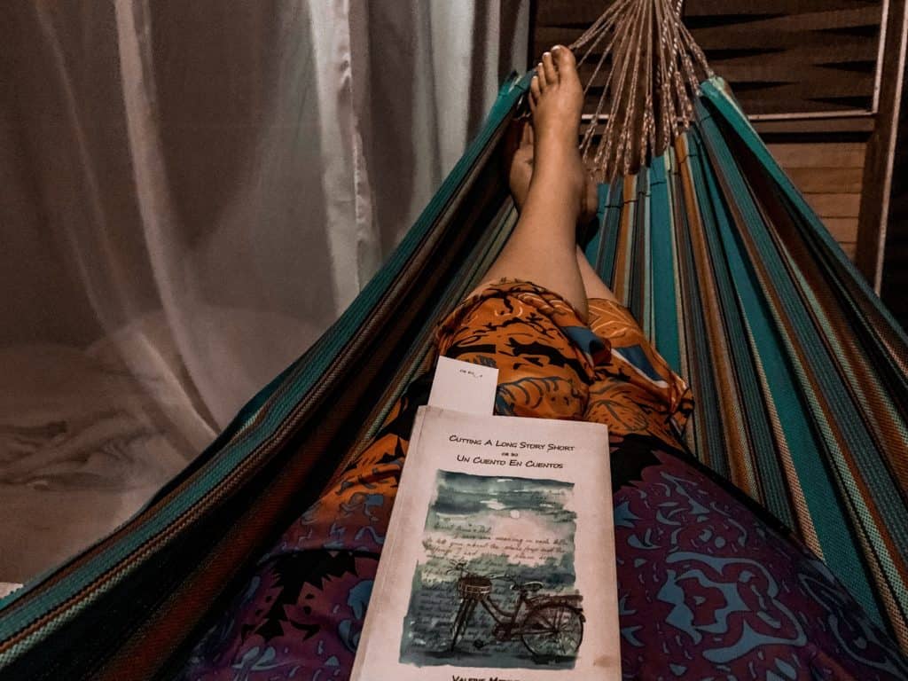 Photos of the Amazon: Reading a book while it storms in the rainforest. This book is by one of the commune's elders.