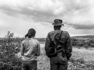 Kunsang walking with a ranger at the waterhole in Enonkishu Conservancy, Maasai Mara, Kenya