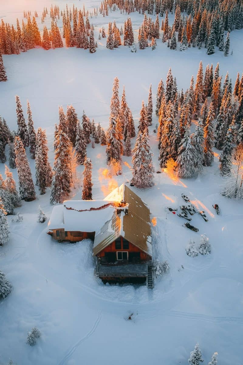 how to save on heating bill: picture of a cabin surrounded by snow