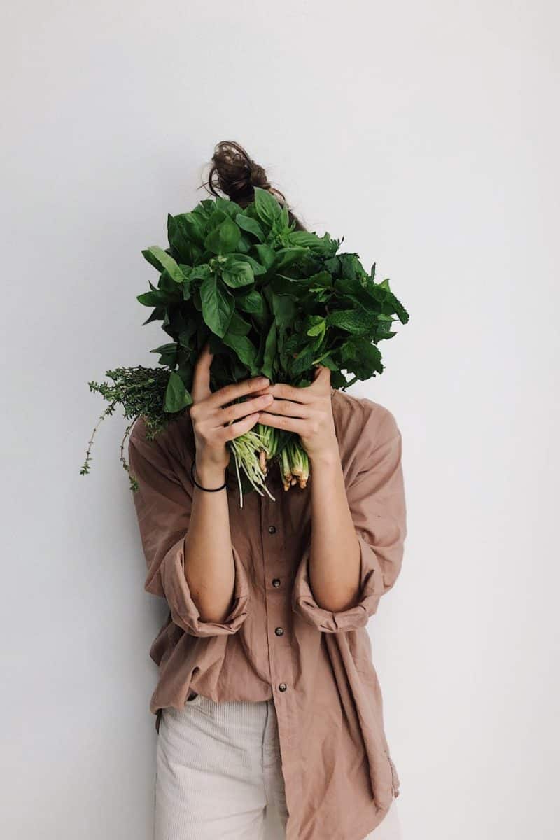 person holding green vegetables