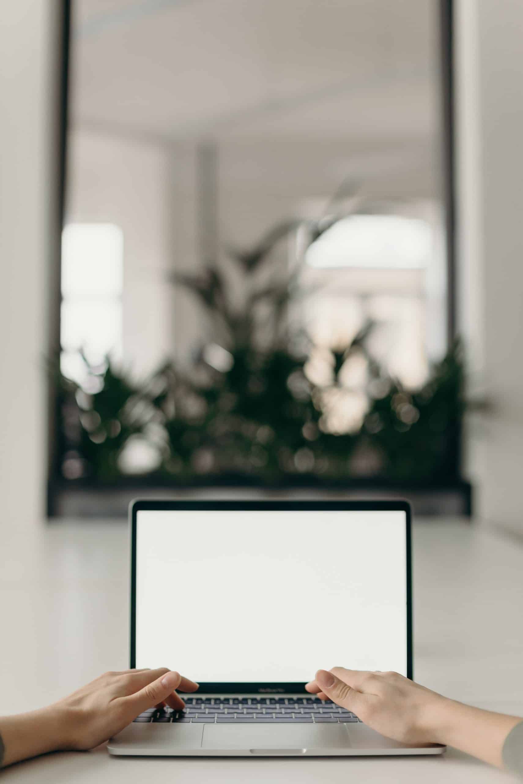 Unhealthy habits that sabotage your productivity. A picture of a man's hands at a computer. There is a large mirror in the background.