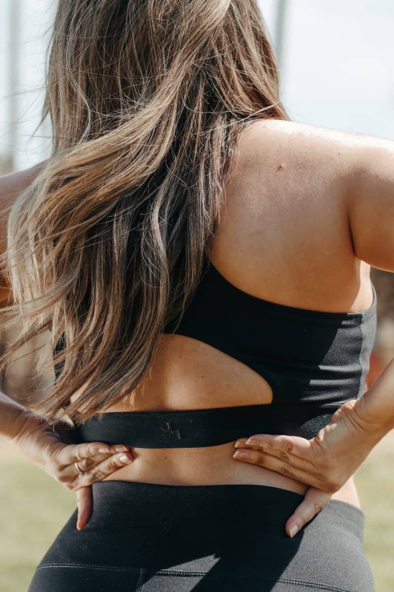 how to heal fast from surgery: woman with long hair wearing athletic clothes