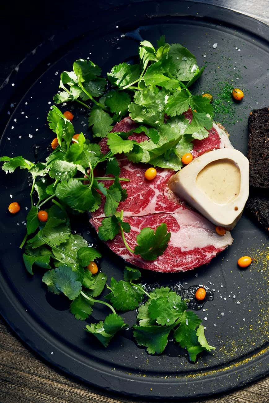 meat served on black plate decorated with parsley