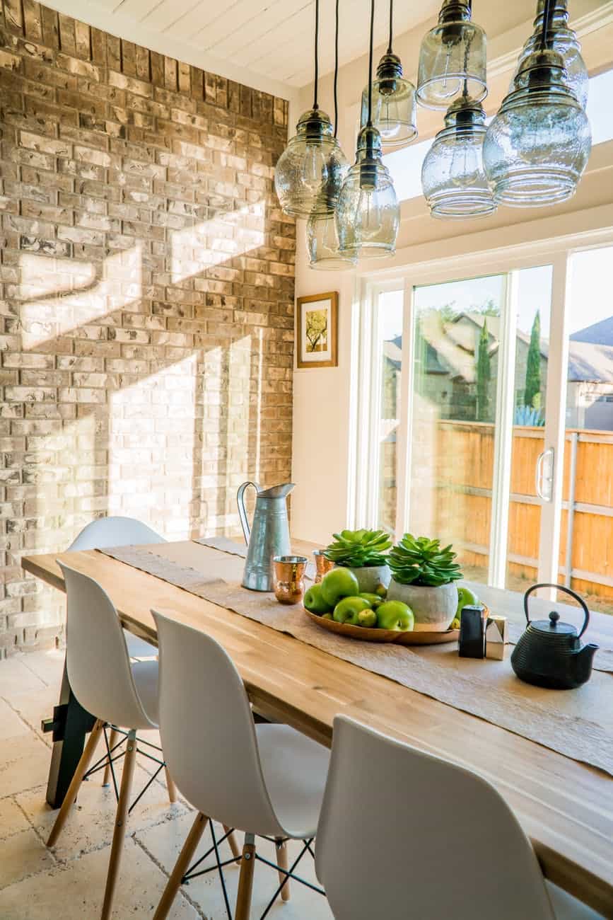 black kettle beside condiment shakers and green fruits and plants on tray on brown wooden table