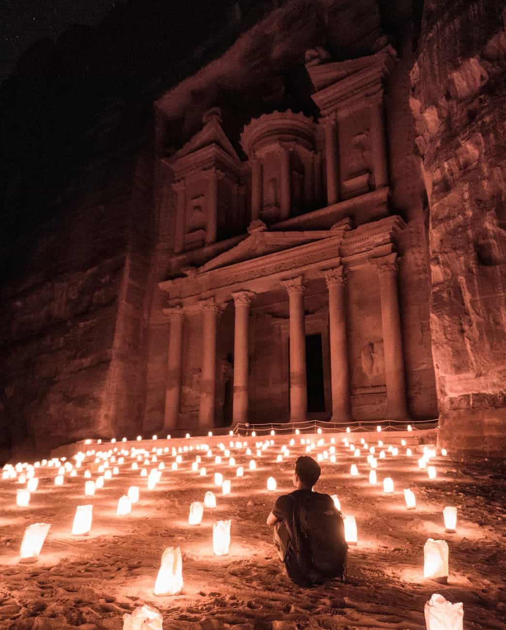 a man sitting outside of the famous petra; responsible travel