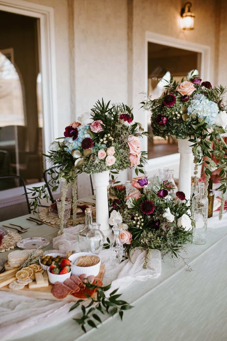 elegant bouquets decorating banquet table with snacks and glassware