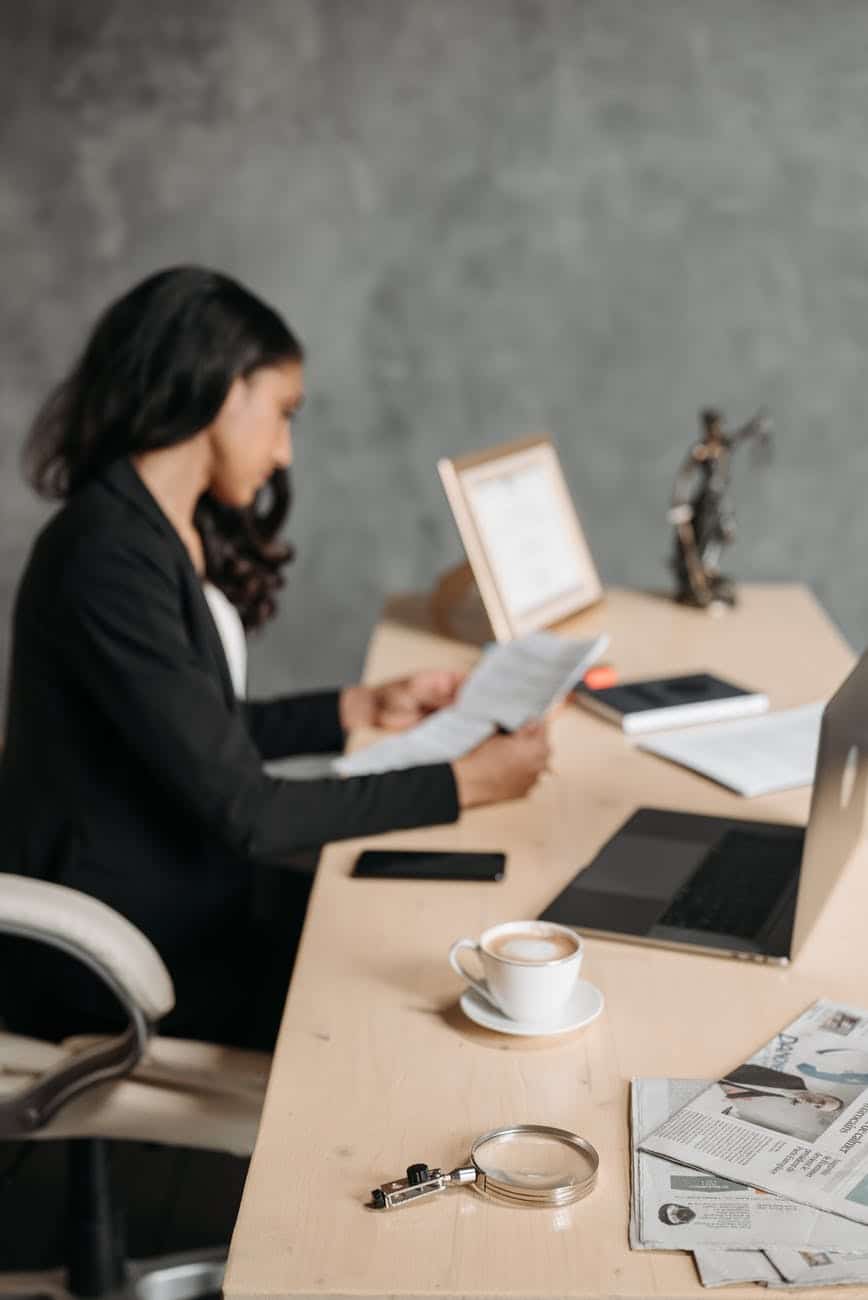 woman in black blazer reading the papers