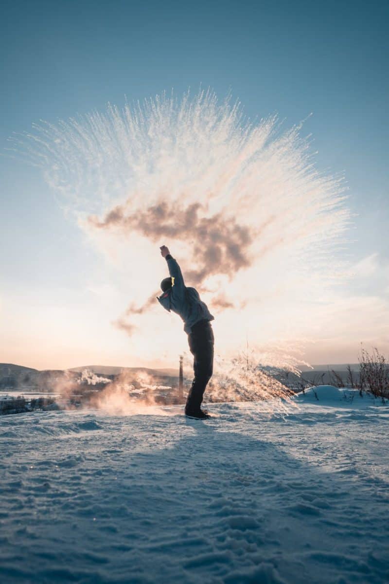 man throwing snow in winter