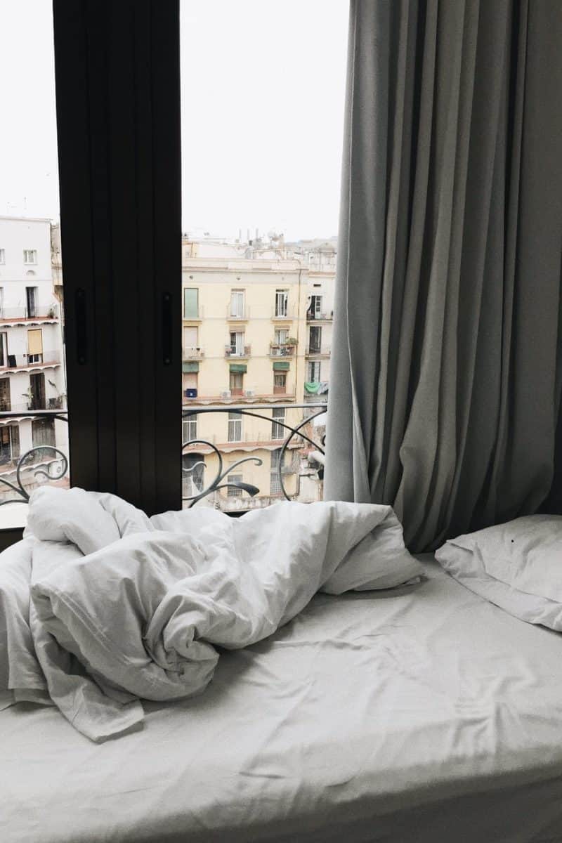 white bedspread beside glass sliding door