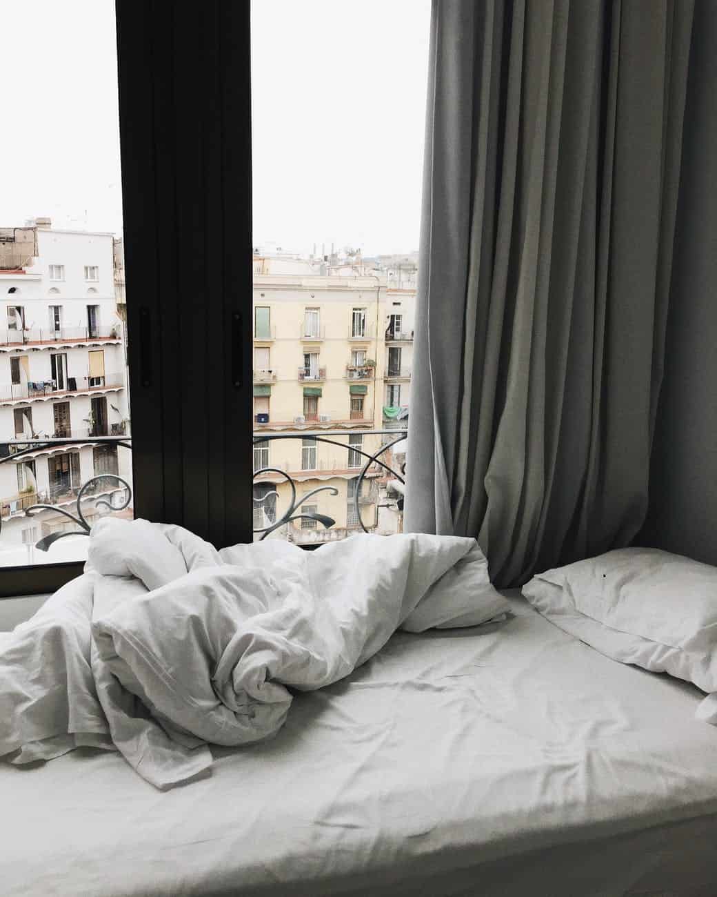 white bedspread beside glass sliding door