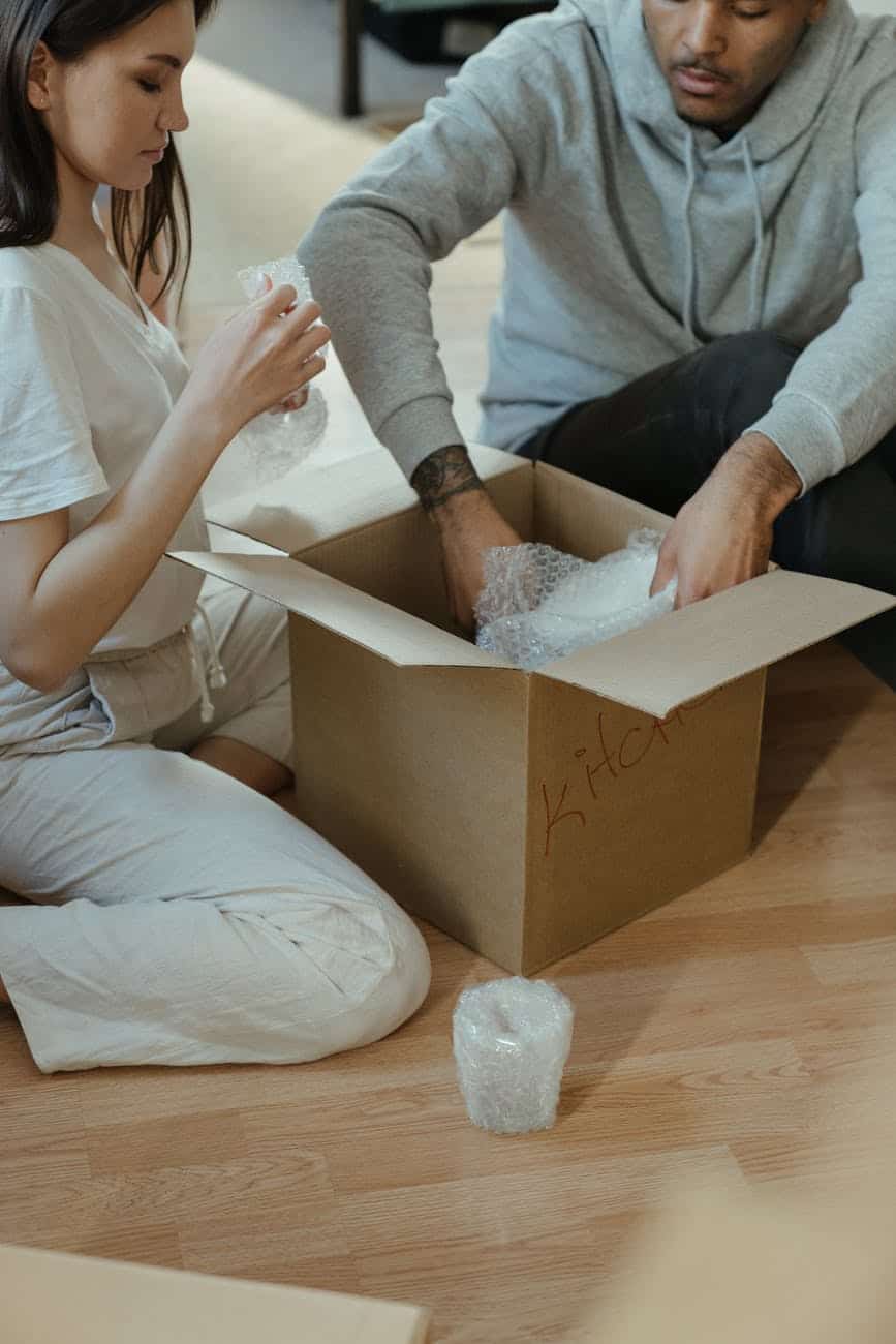 woman in gray long sleeve shirt and white pants sitting on brown wooden table