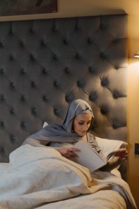 woman in white hijab lying on bed