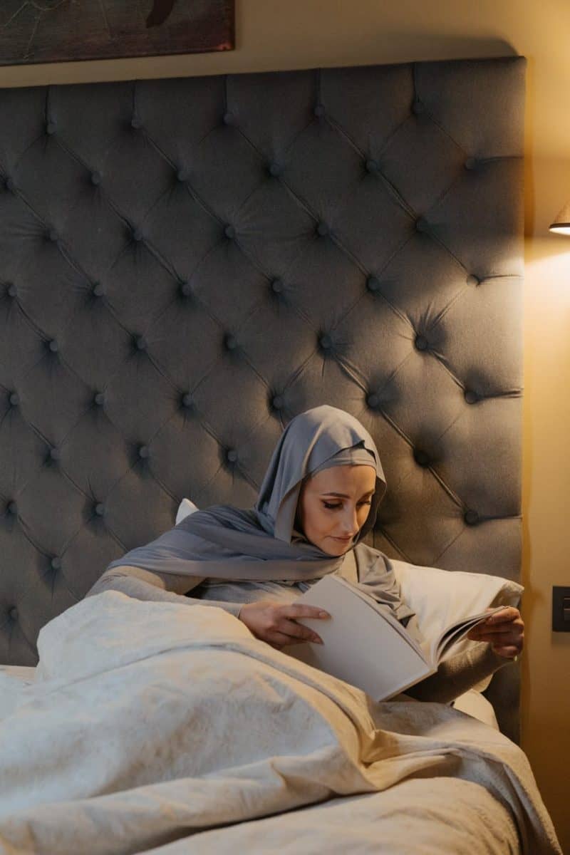 woman in white hijab lying on bed