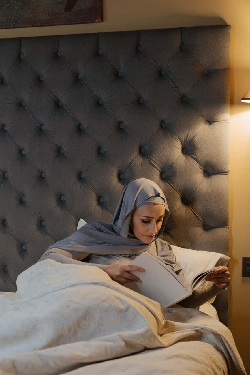 woman in white hijab lying on bed