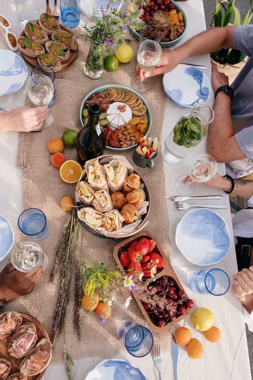 person in blue t shirt sitting on chair in front of table with foods