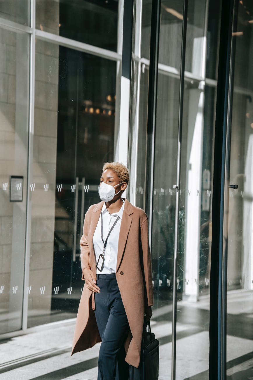 confident ethnic woman leaving contemporary building after workday