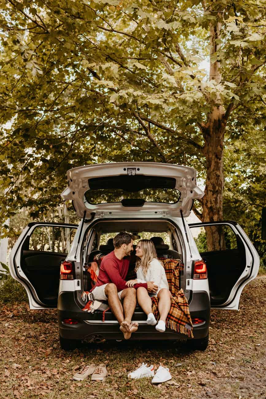 photo of couple sitting in the back of car