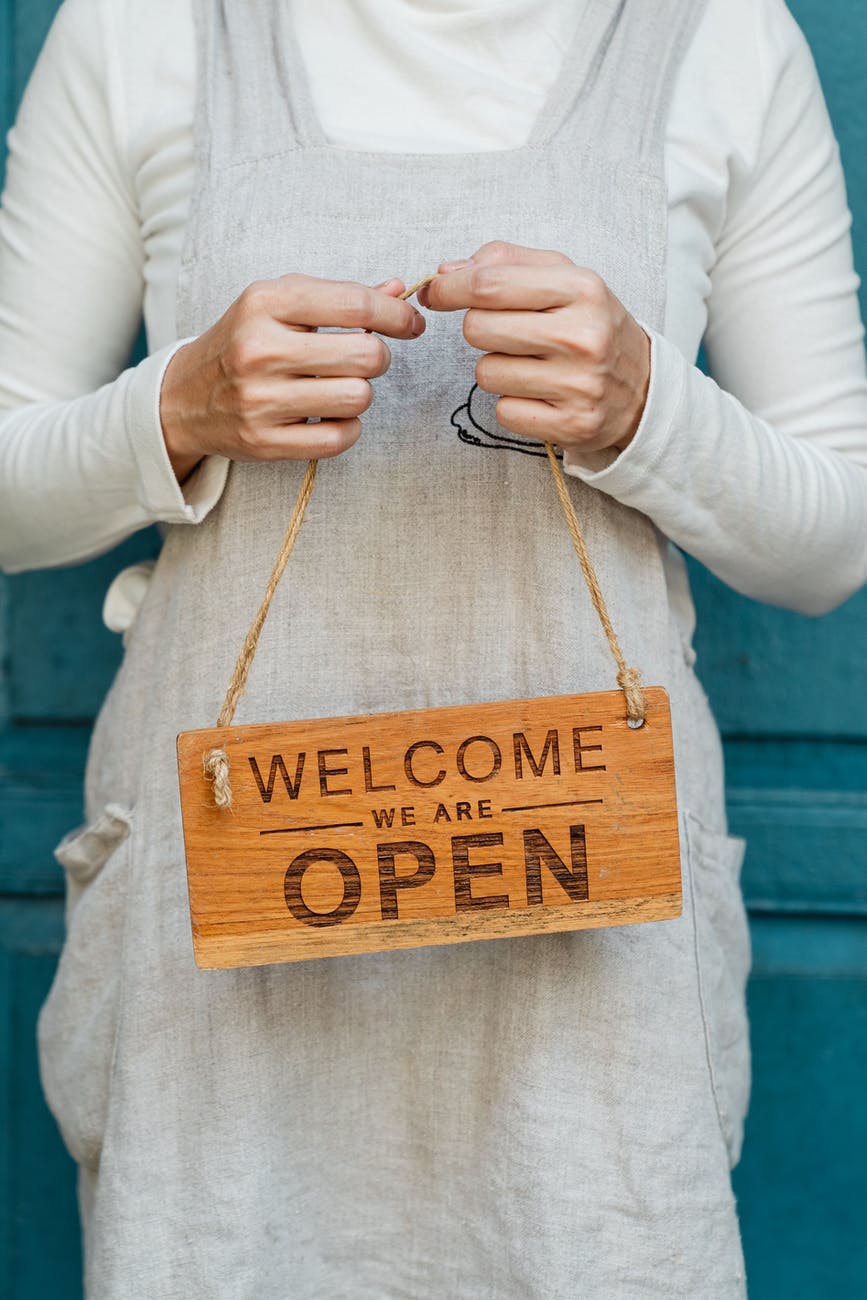 crop woman with open sign