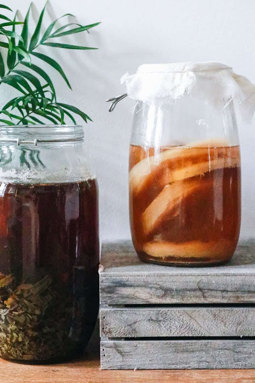 jars with kombucha and dark herbal beverage