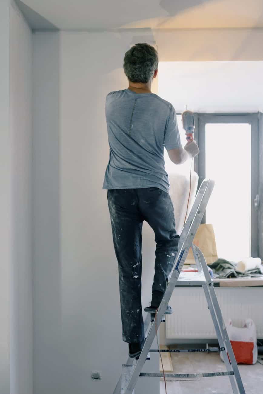 male builder with instrument in apartment