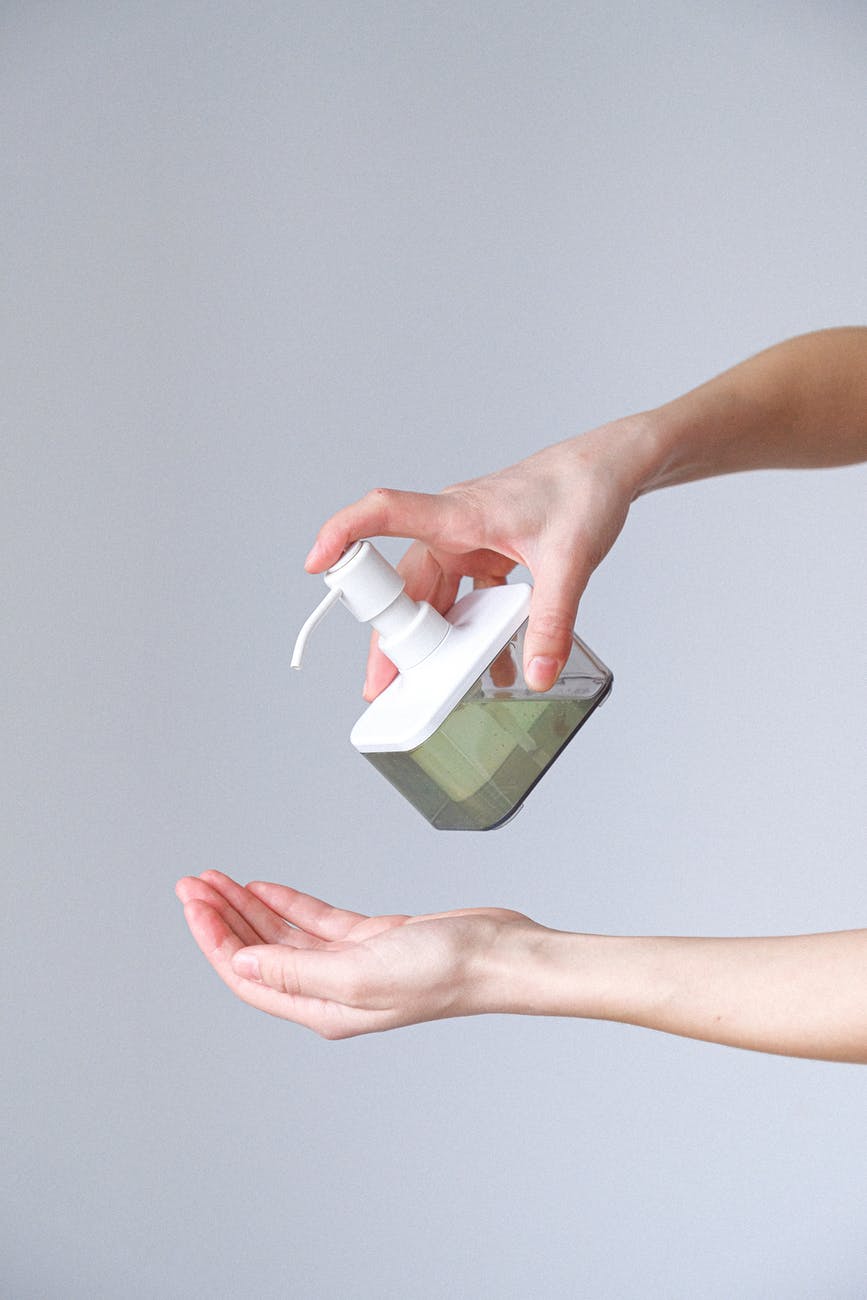 woman applying hand sanitizer