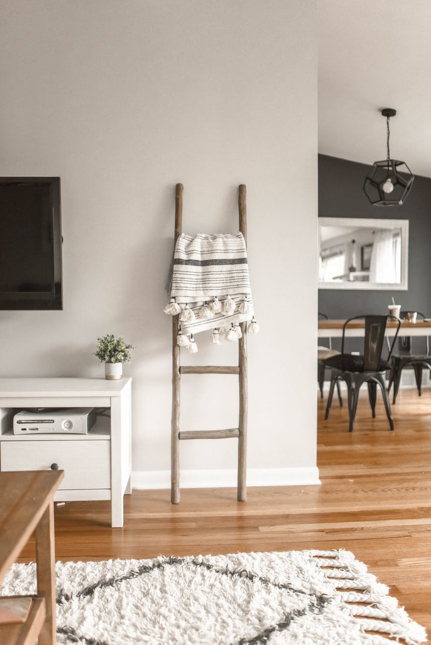 gray wooden ladder on white painted wall