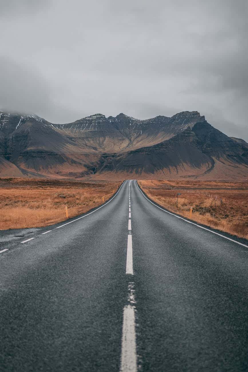 empty highway overlooking mountain under dark skies