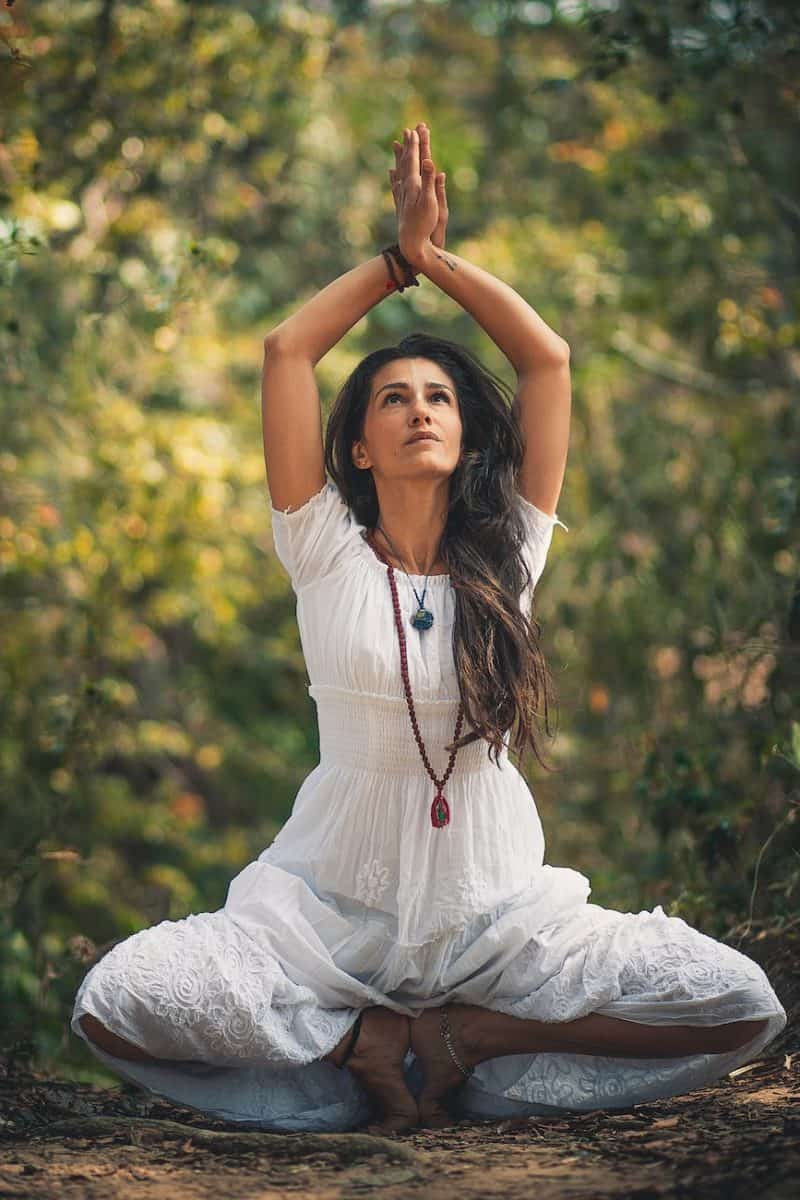 woman squatting on ground while raising both hands