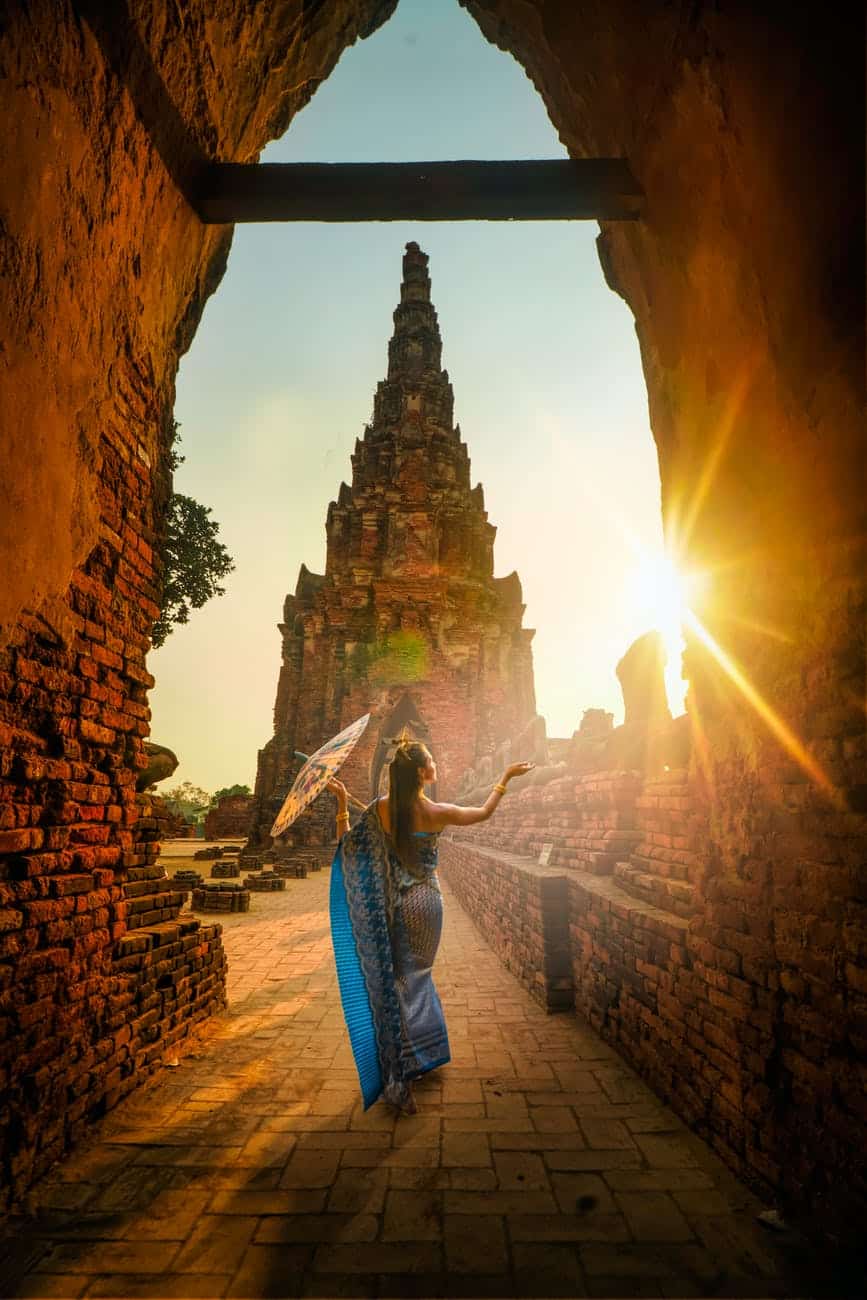 woman wearing blue dress with umbrella during sunset