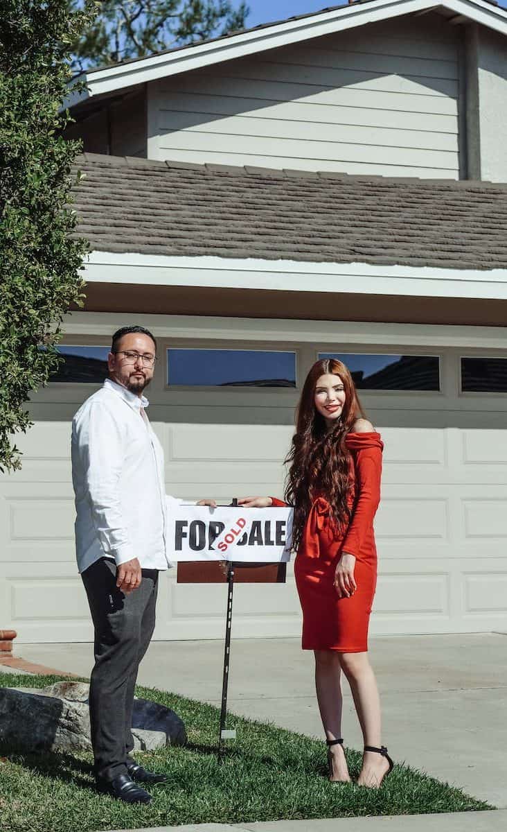 man and woman standing in front of their house