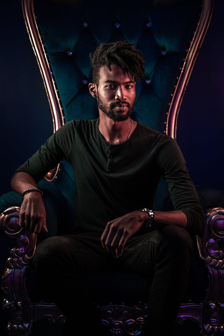 a man in black long sleeve shirt sitting on chair