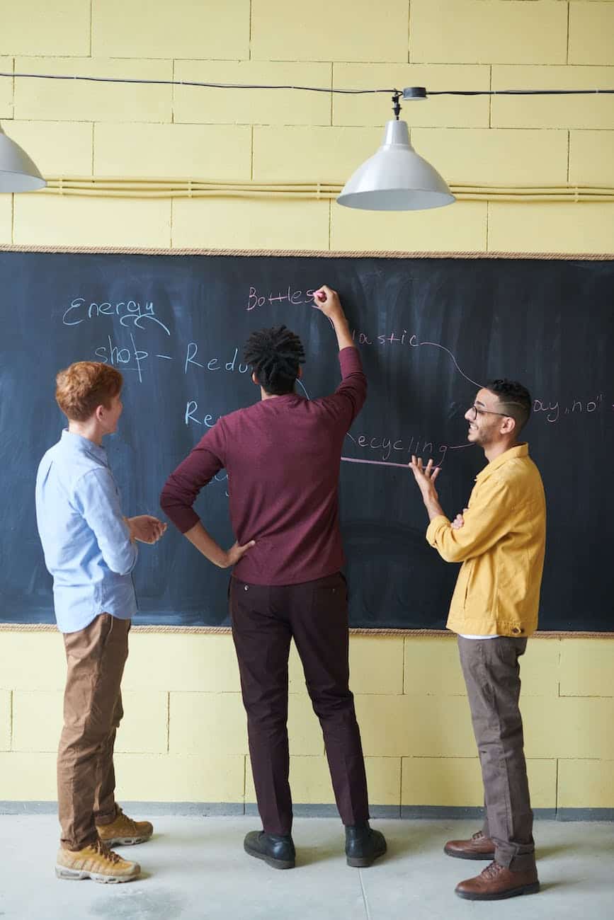 photo of man writing on blackboard