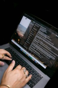 unrecognizable woman using chat while typing on laptop at home