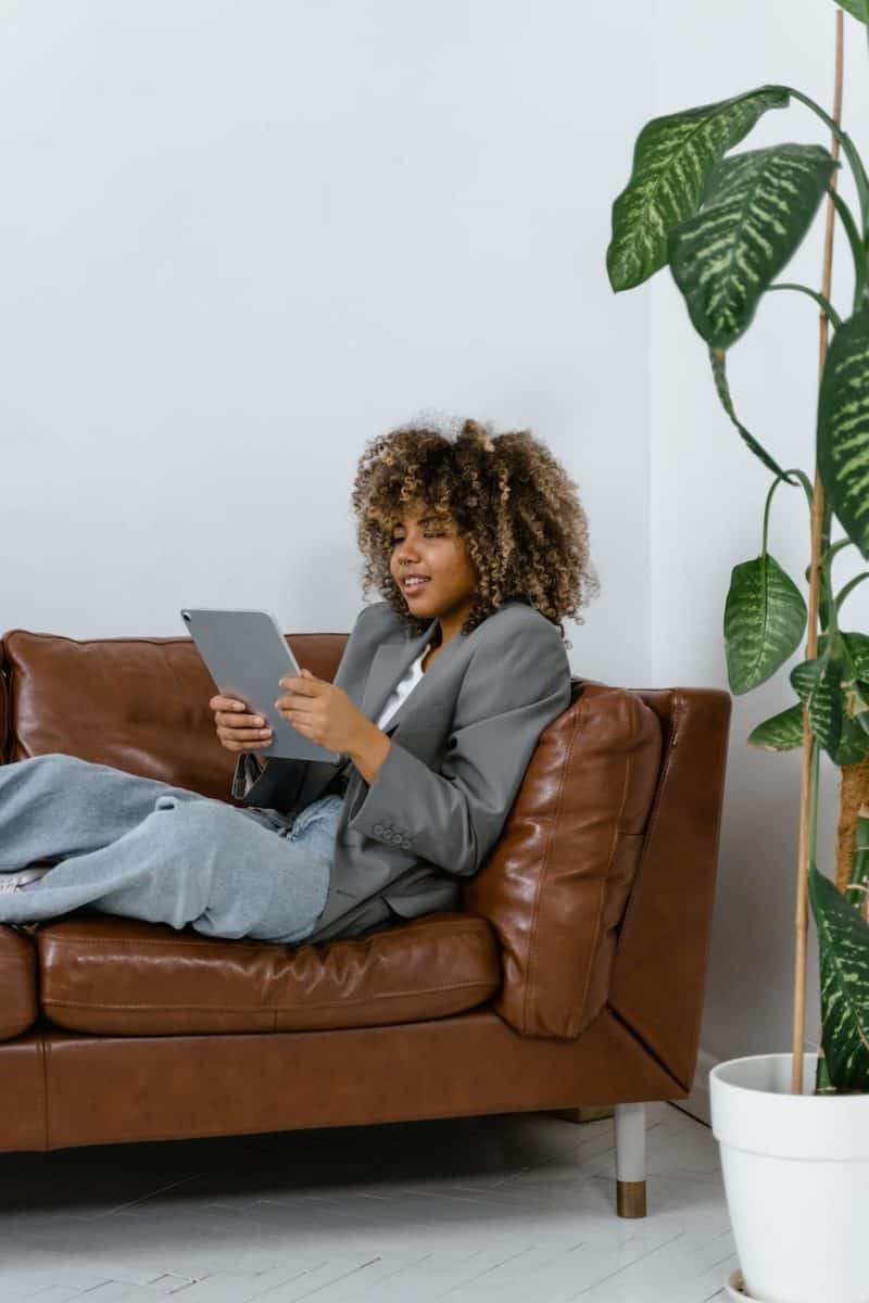 woman sitting on brown leather couch