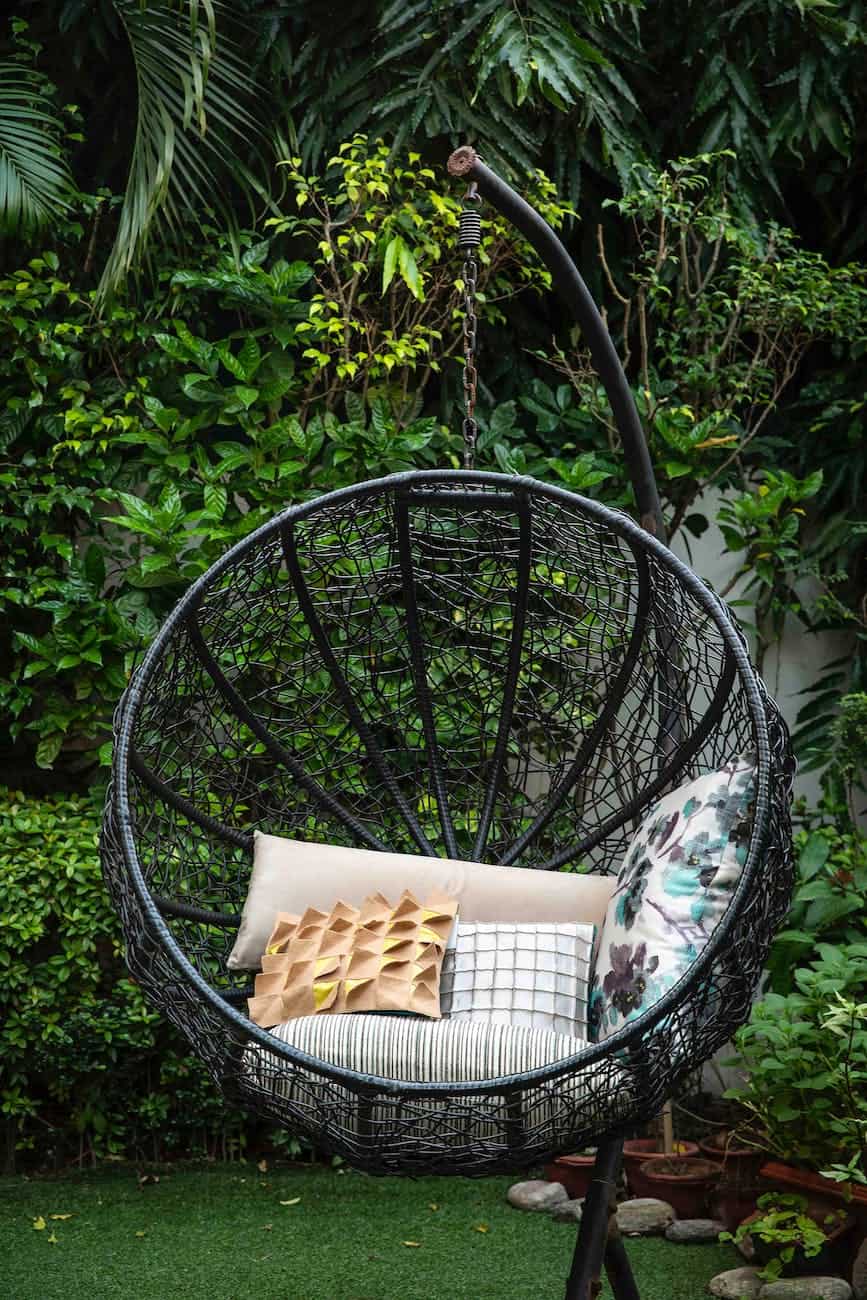 black metal framed round basket with brown and white throw pillows