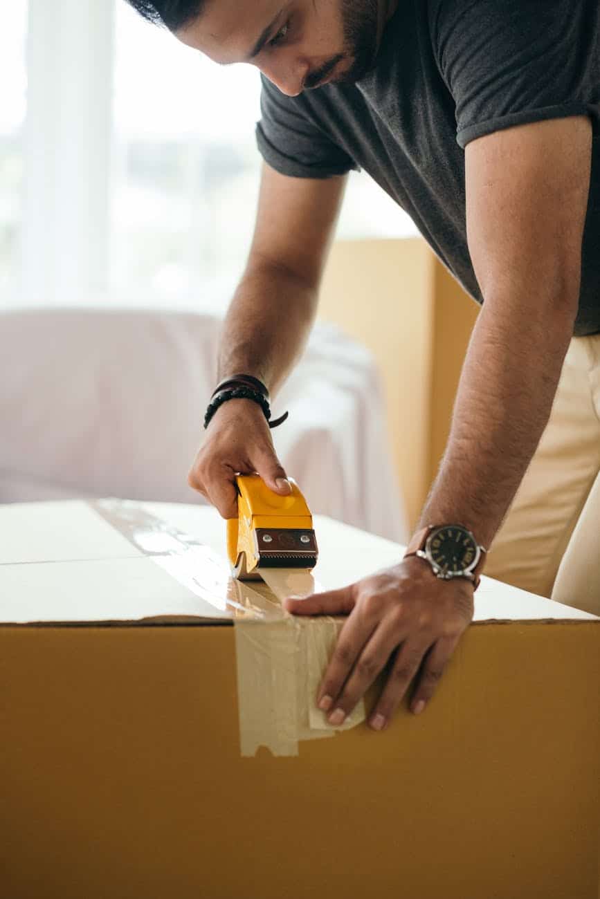 crop man taping carton box while moving