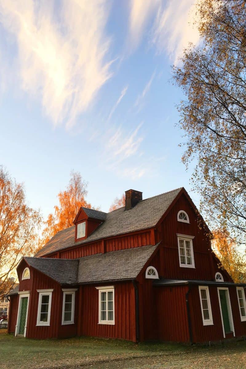 red and black wooden house under blue sky
