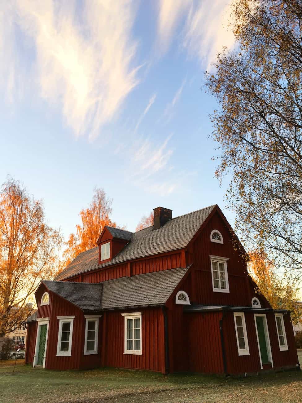 red and black wooden house under blue sky