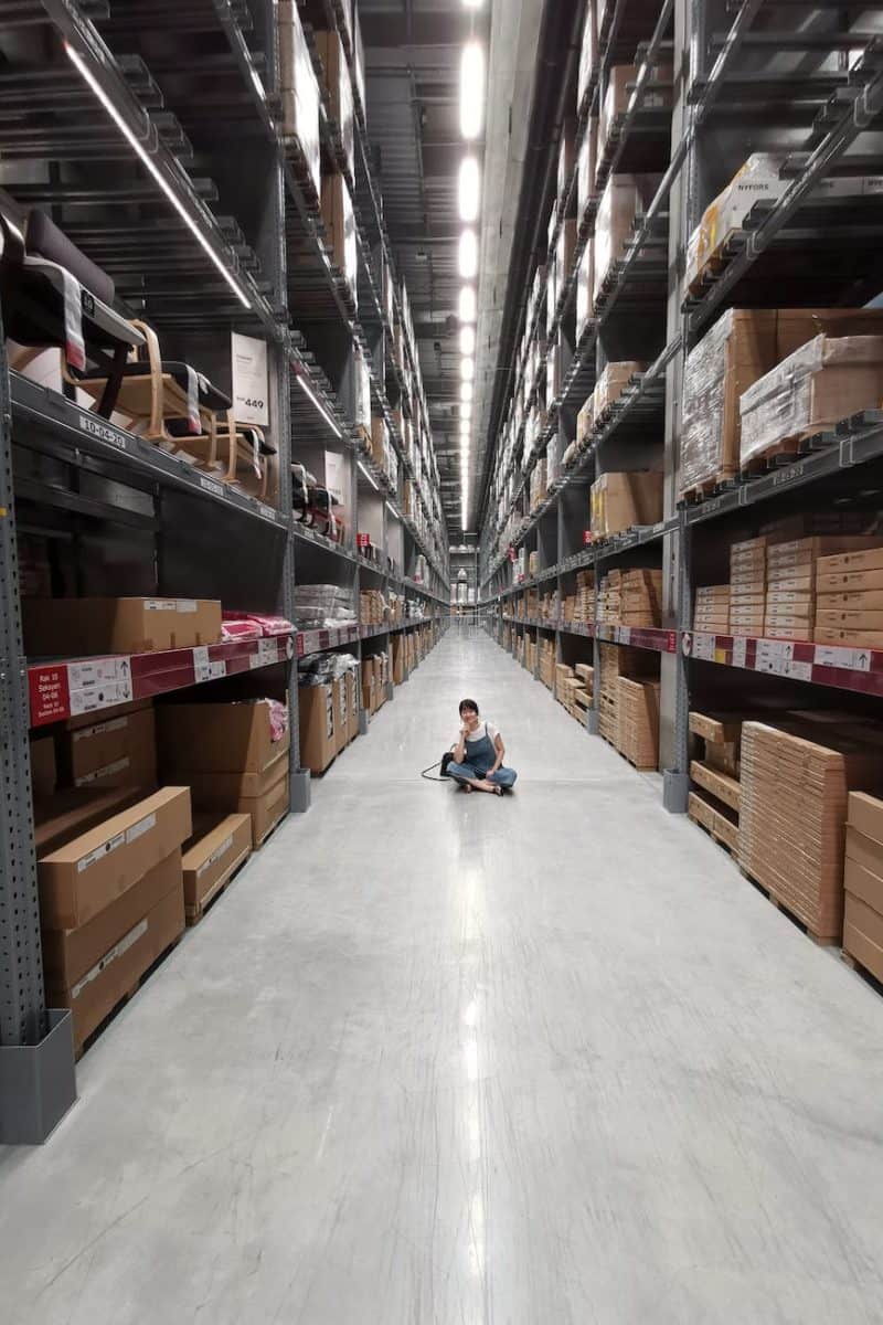 person sitting on ground between brown cardboard boxes