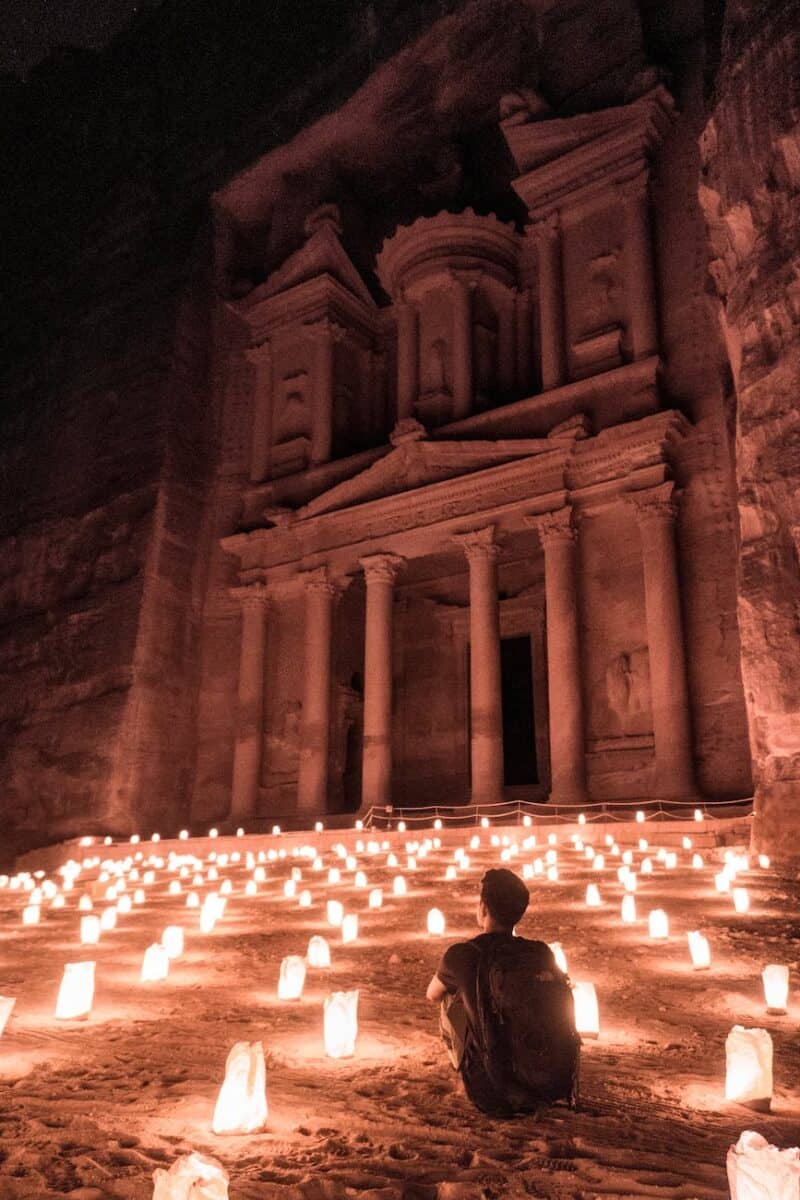 a man sitting outside of the famous petra