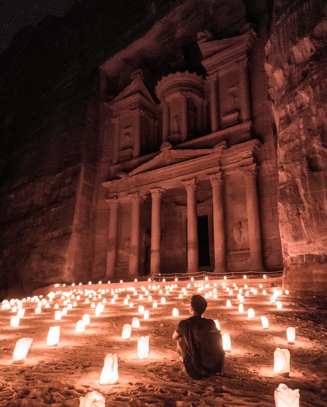 a man sitting outside of the famous petra