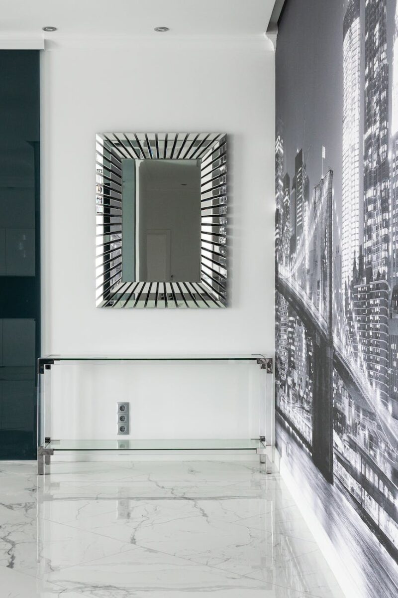 apartment interior with mirror and table near city wall mural