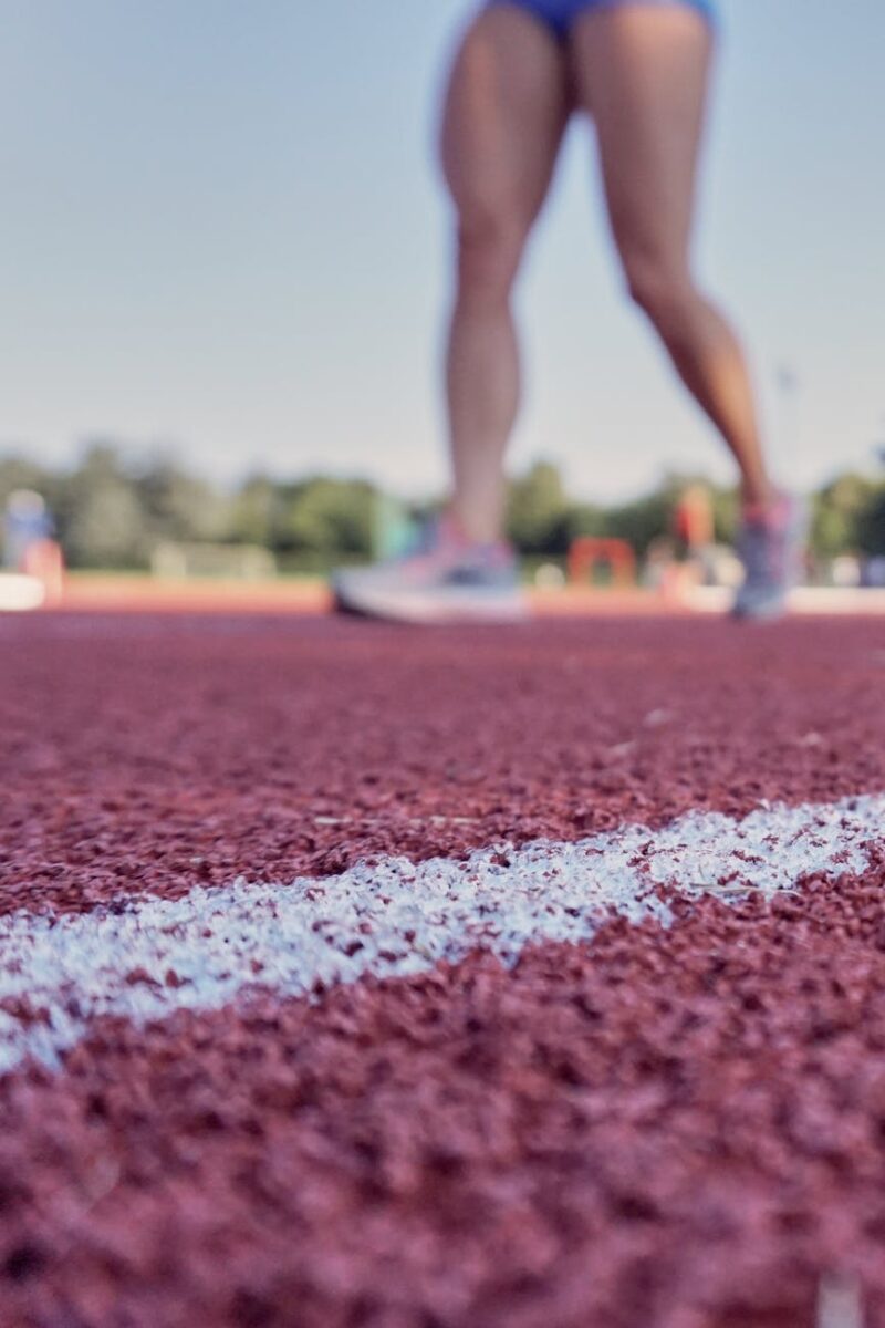 person wearing running shoes on running field