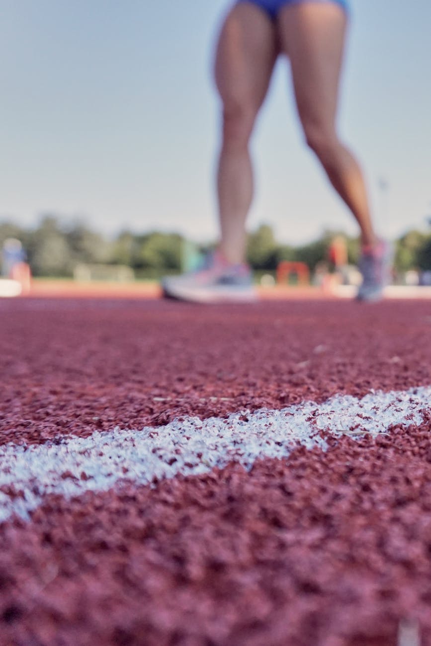 person wearing running shoes on running field