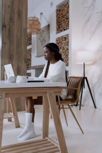 woman in white shirt sitting on brown wooden chair