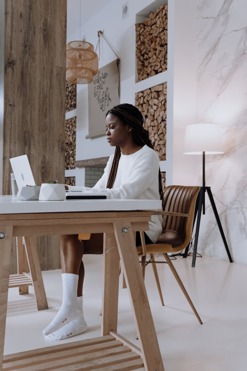 woman in white shirt sitting on brown wooden chair