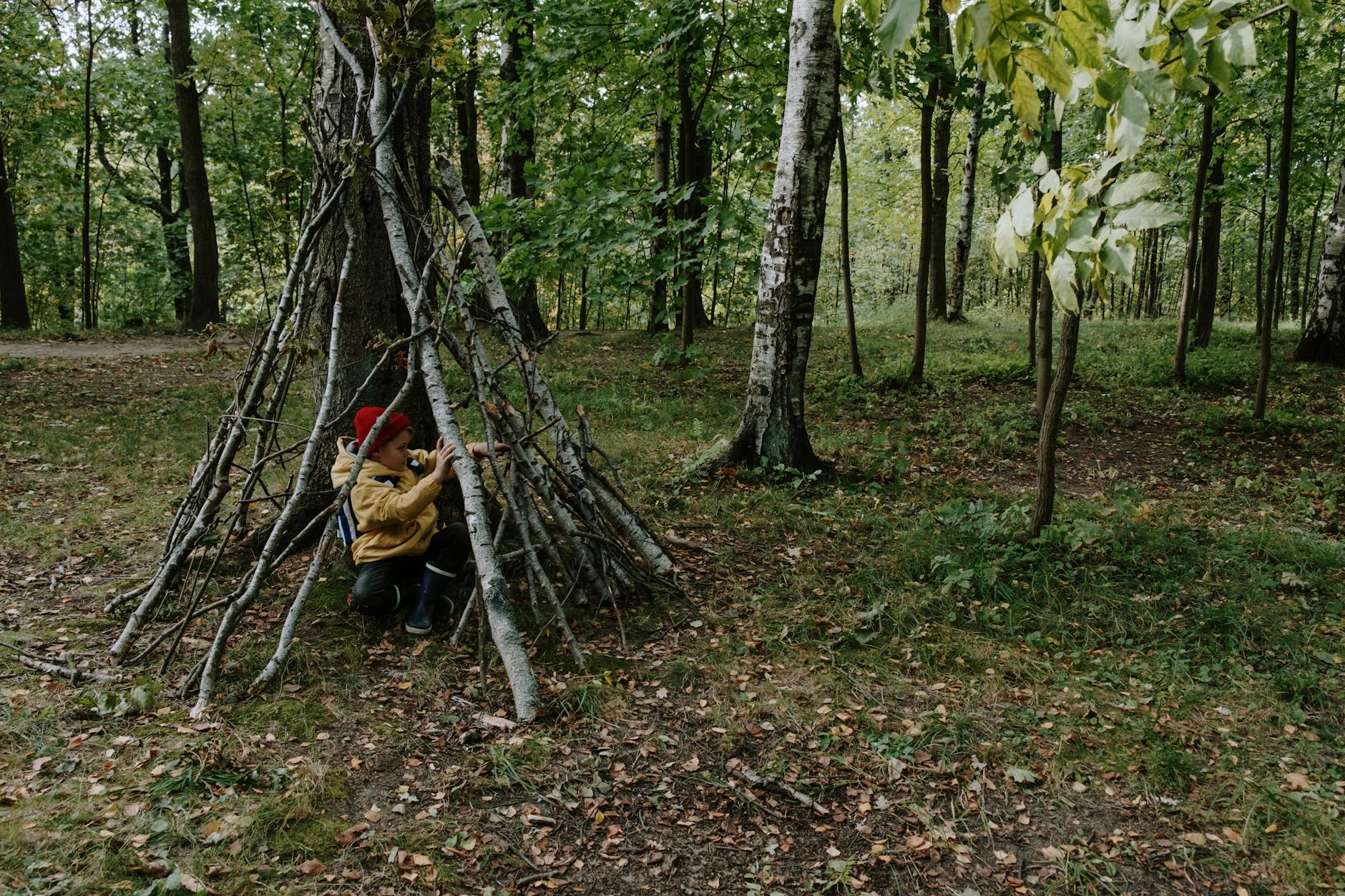 a boy hiding behind the wooden sticks