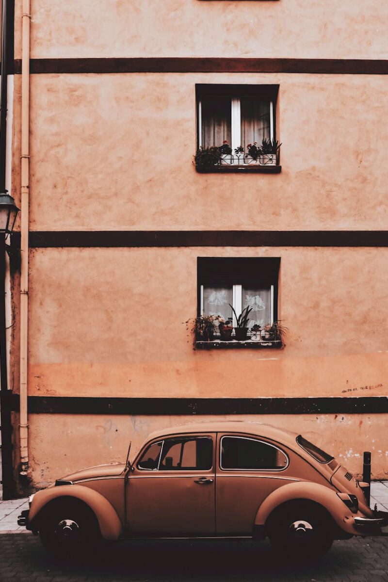 beige volkswagen beetle coupe parked near concrete building